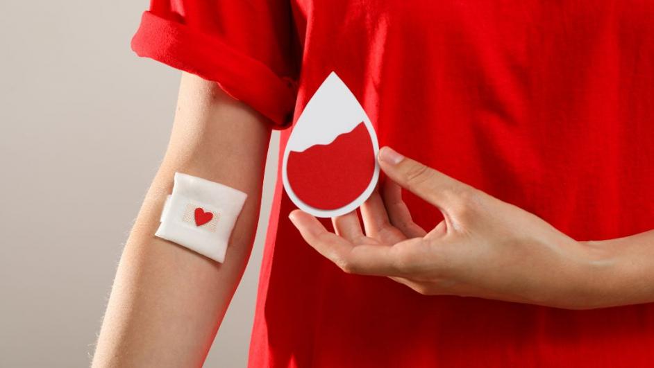 rappresentazione della donazione di sangue: persona con maglietta rossa e cerotto al braccio