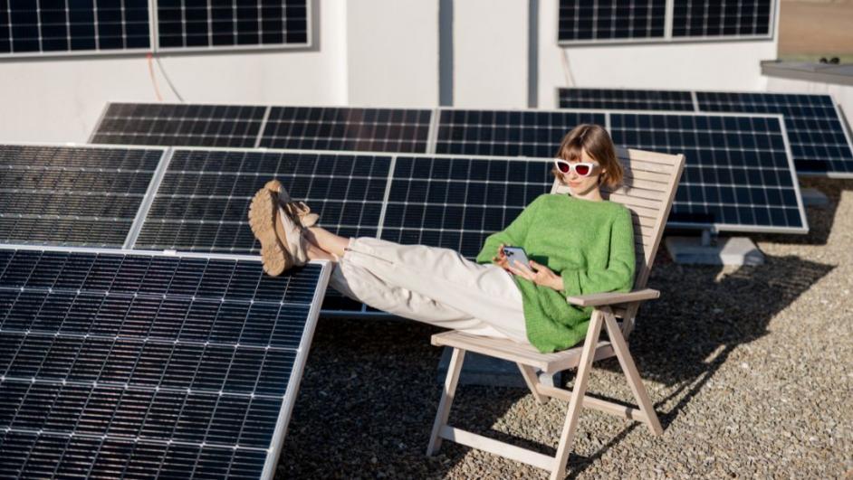 ragazza seduta su una sdraio circondata da pannelli solari